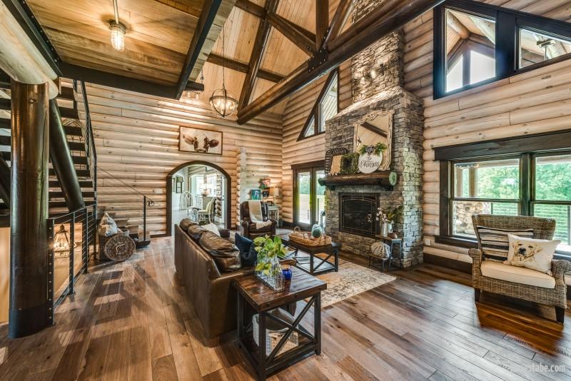 Livingroom with large round log interior and exterior walls and geometric windows