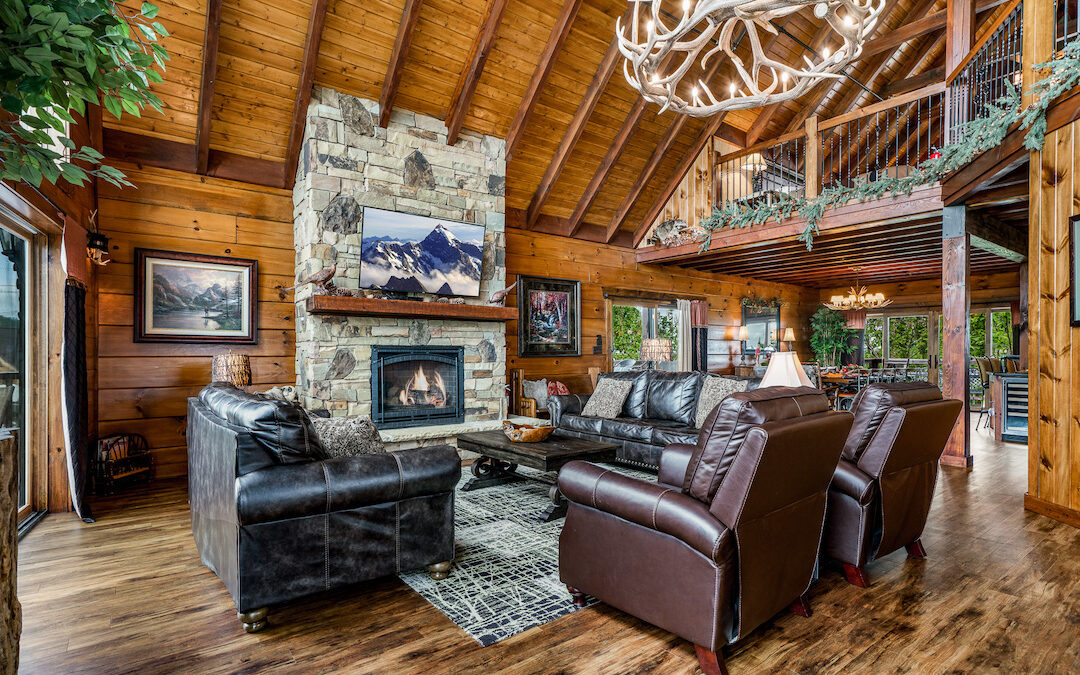 log home living room with open loft over the dining space. dark wood walls and ceiling